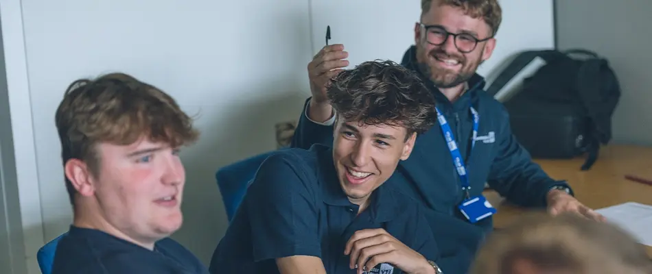 Two young male apprentices talking and smiling