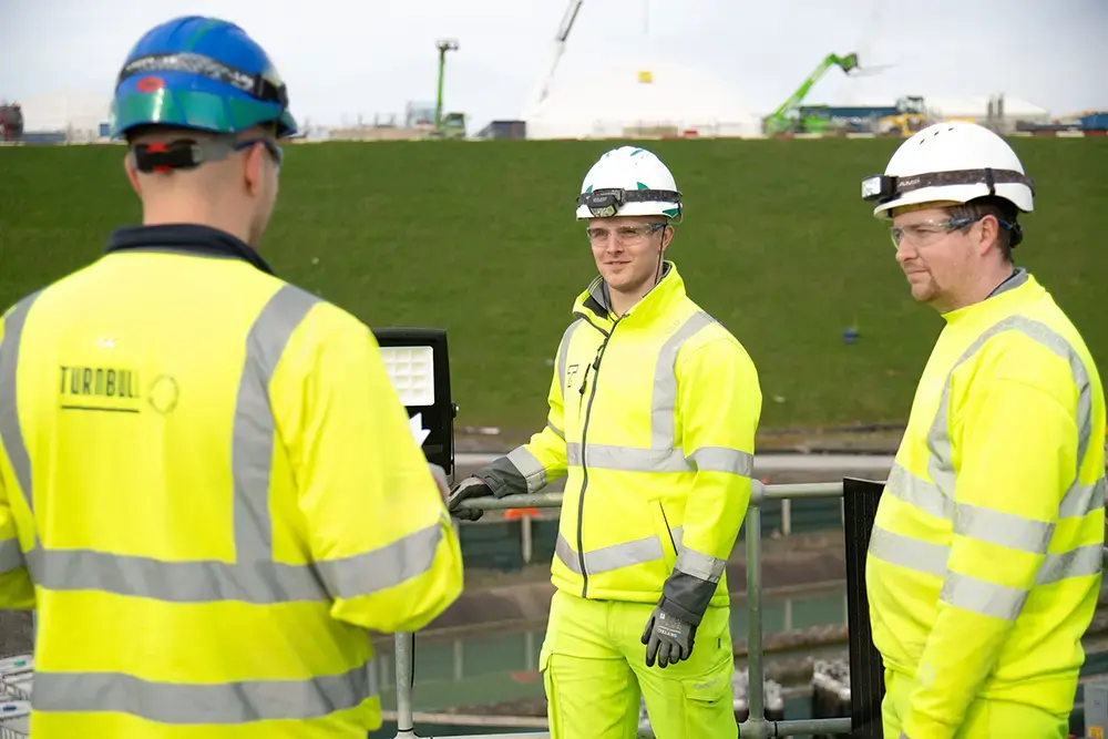 Turnbull employees outside in hi vis and hard hats