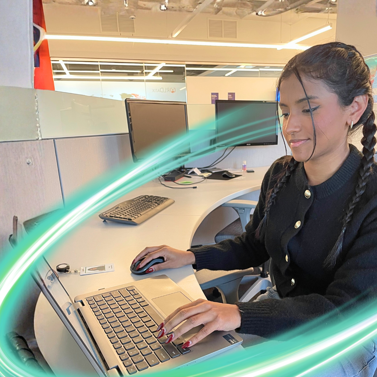 A person is looking down at a computer smiling and wearing black. There is a electric teal and light green neon oval over the photo.