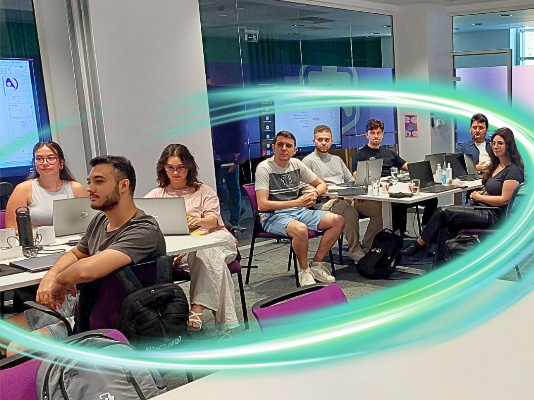 People sitting in a room with computers in front of them and a large electric, glowing teal circle surrounding them.