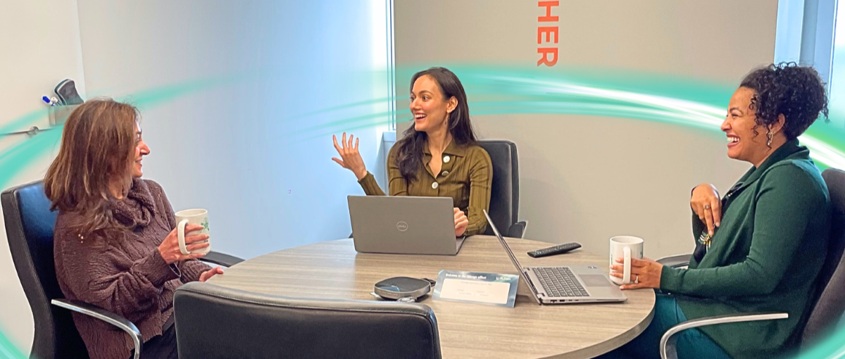 Three people are sitting side by side. They are chatting and smiling. There is a teal circle around them.