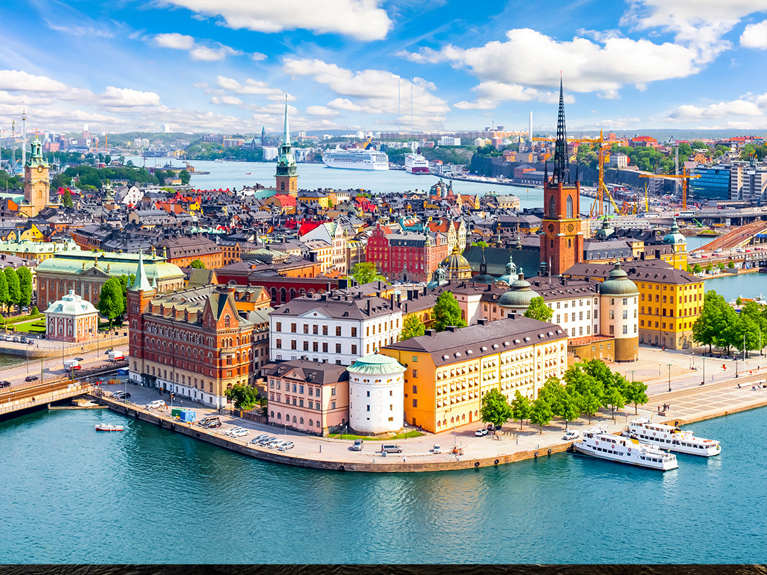 A bird's eye view of the city skyline of Stockholm and the river in the front. It is the evening with a light blue and clouded sky. There is a electric teal and light green neon oval over the photo.