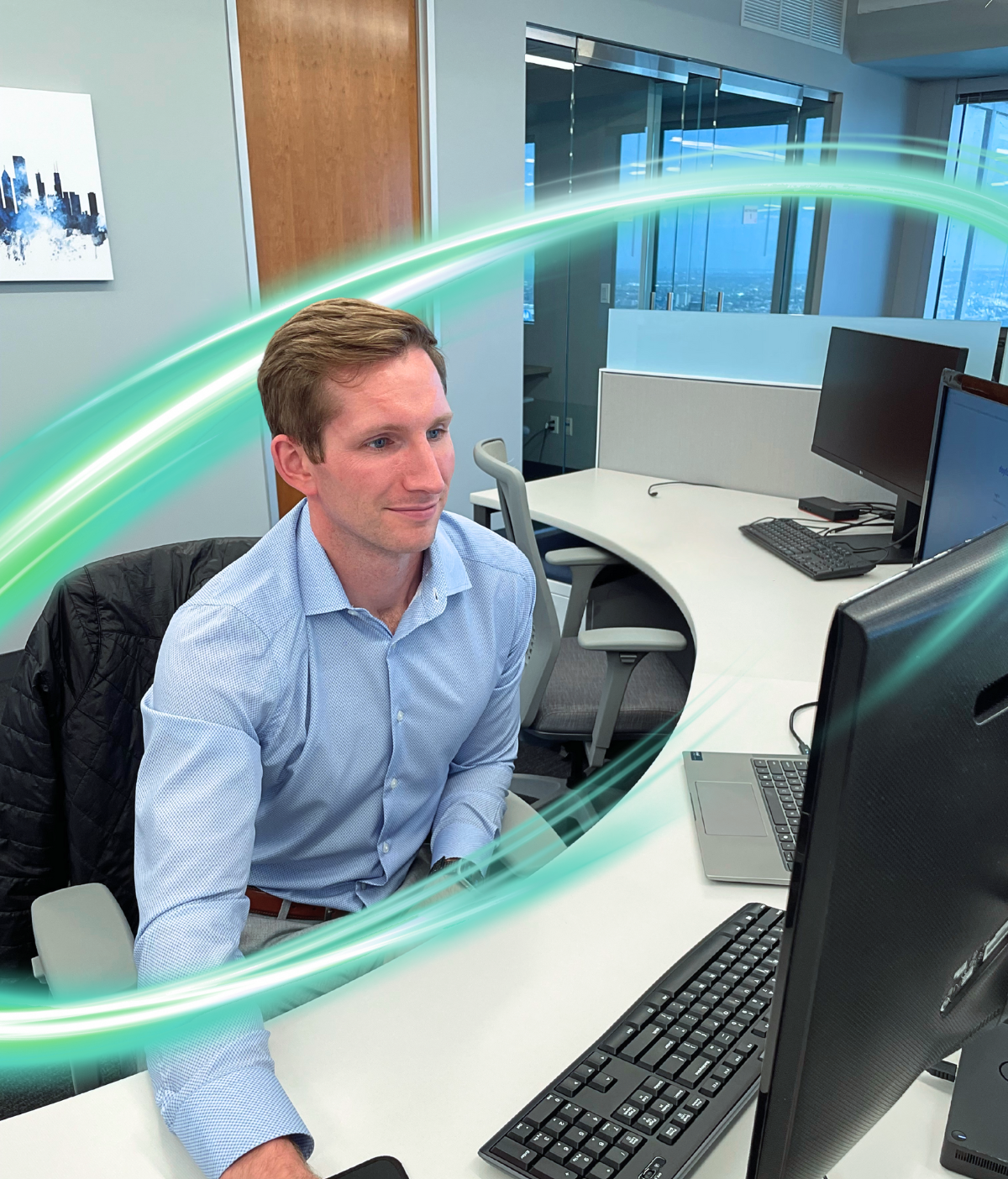 Man looking at a computer screen. There is a electric teal and light green neon oval over the photo.