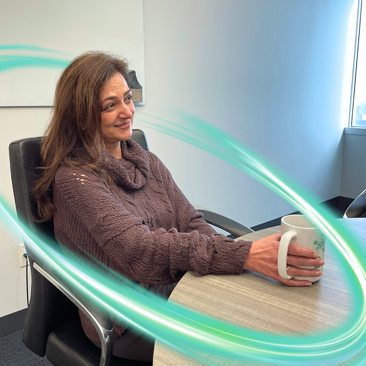 Two employees are sitting on a white couch with microphones in front of them. The RLDatix logo is behind them and there is light brown paneling on the wall. There is a electric teal and light green neon oval over the photo.
