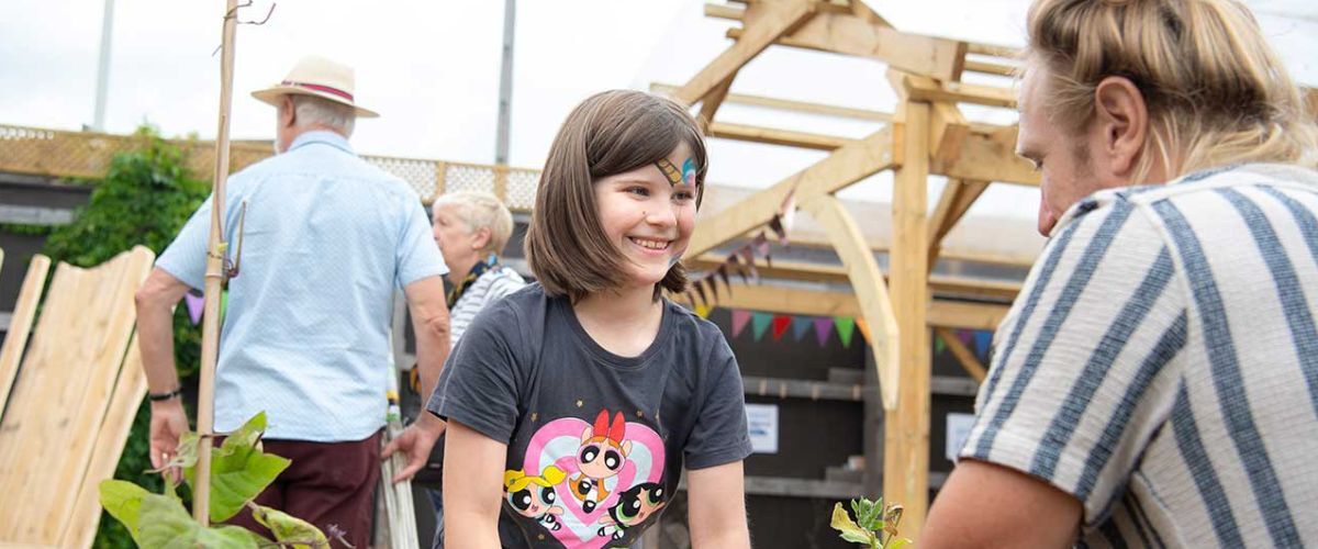A girl smiling while helping with plants