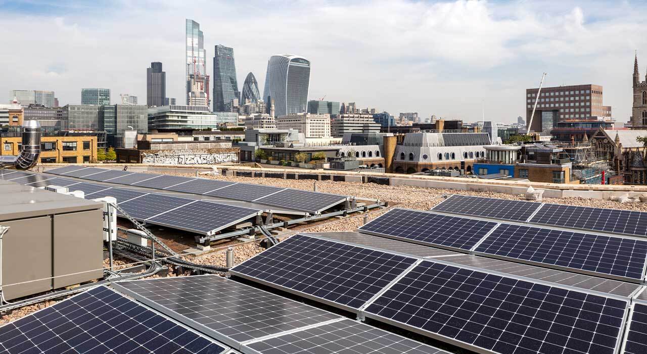 solar panels on top of a building with central London in the background