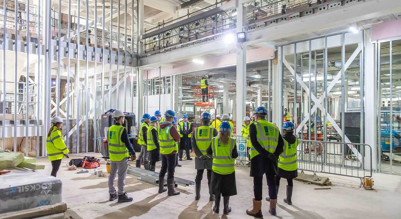 Person, Worker, Architecture, Building, Footwear, Shoe, Groupshot, Helmet, Jeans, Pants